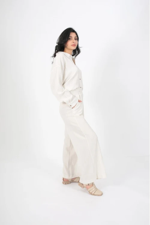 طقم نسائي أنيق قطعتين لون ابيض قميص أكمام طويلة بياقة و أزرار أمامية و بنطلون واسع طويل بجيوب