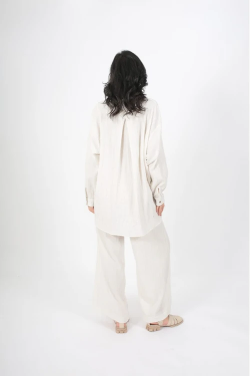 طقم نسائي أنيق قطعتين لون ابيض قميص أكمام طويلة بياقة و أزرار أمامية و بنطلون واسع طويل بجيوب