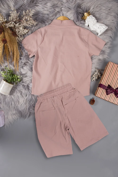 طقم ولادي قطعتين لون وردي أكمام قصيرة بياقة بأزرار قفل وجيب بطبعات من الامام وشورت بجيوب و رباط من الخصر