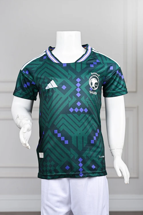 تيشيرت المنتخب السعودي شبابي لون أخضر داكن مع الشعار مزين بنمط هندسي و بزخارف ومنسوجات تراثية سعودية ياقة دائرية بلونين الأخضر و البنفسجي و بأكمام قصيرة