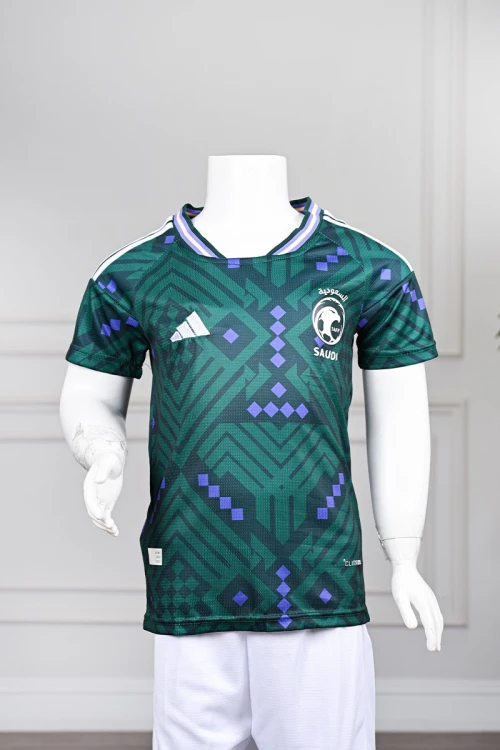 تيشيرت المنتخب السعودي شبابي لون أخضر داكن مع الشعار مزين بنمط هندسي و بزخارف ومنسوجات تراثية سعودية ياقة دائرية بلونين الأخضر و البنفسجي و بأكمام قصيرة