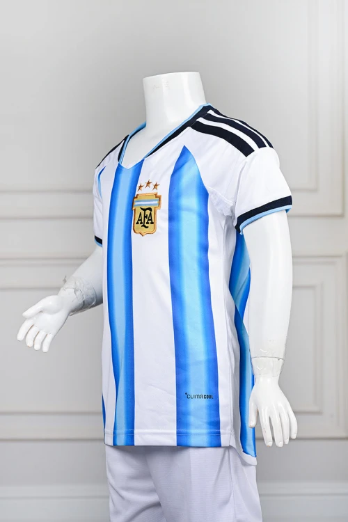 تيشيرت رياضي شبابي لمنتخب الأرجنتين مع الشعار لون أبيض مع خطوط عمودية باللون السماوي ياقة دائرية باللون السماوي مع اللون الكحلي على الكتفين و الأكمام