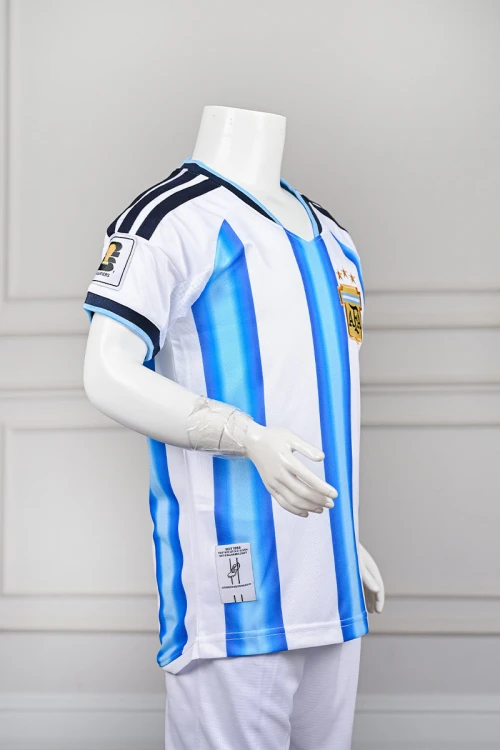 تيشيرت رياضي شبابي لمنتخب الأرجنتين مع الشعار لون أبيض مع خطوط عمودية باللون السماوي ياقة دائرية باللون السماوي مع اللون الكحلي على الكتفين و الأكمام