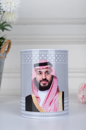 حصالة نقود معدنية أسطوانية لون رمادي فاتح مزينة بصورة صاحب السمو الملكي الأمير محمد بن سلمان