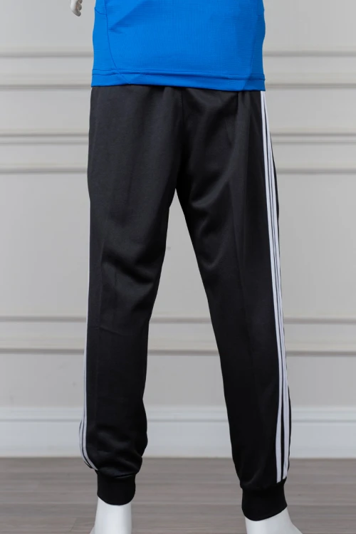 بنطلون ولادي رياضي طويل لون أسود بثلاثة خطوط بيضاء جانبية و أطراف مطاطية عند الكاحل