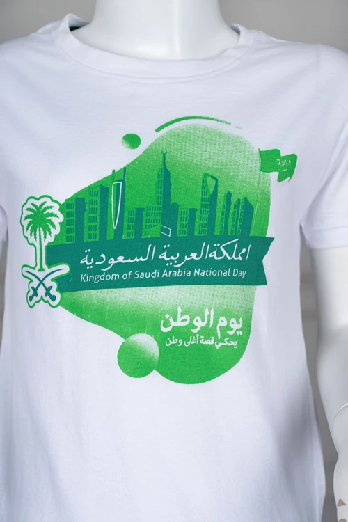 تيشيرت ولادي لون أبيض بطبعة اليوم الوطني باللونين التفاحي و الأخضر ياقة دائرية و أكمام قصيرة