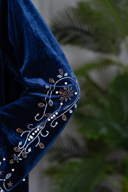 جلابية نسائية طويلة لون كحلي مزينة بفصوص و حبات اللؤلؤ في الياقة من الأمام و أطراف الأكمام