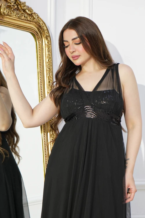 فستان سهرة نسائي اسود طويل أنيق أكمام طويلة شفافة وقماش لامع من الصدر بكسرات سفلية أمامية