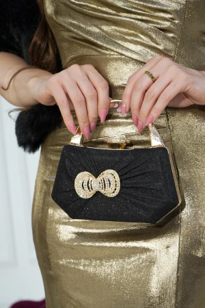 شنطة سهرات نسائية أنيقة باللون الاسود اللامع والذهبي مع بروش كريستالي بشكل فيونكة