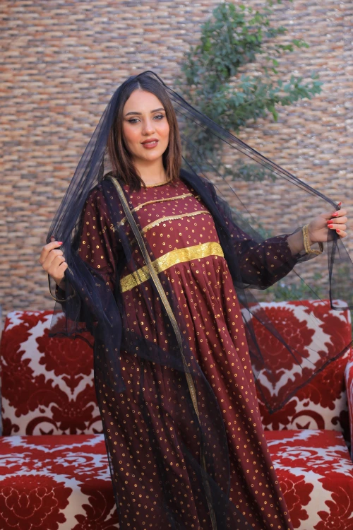 فستان تراثي نسائي أنيق قطعتين لون عودي بتطريز وطبعات لامعة باللون الذهبي مع عباية شفافة باللون الأسود