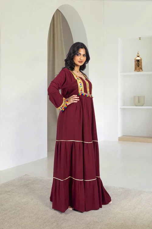 جلابية نسائي أنيقة فتحة الصدر شكل مربع بكسرات من الخصر وتزيين باللون الذهبي ودناديش ملونة في الصدر والأكمام