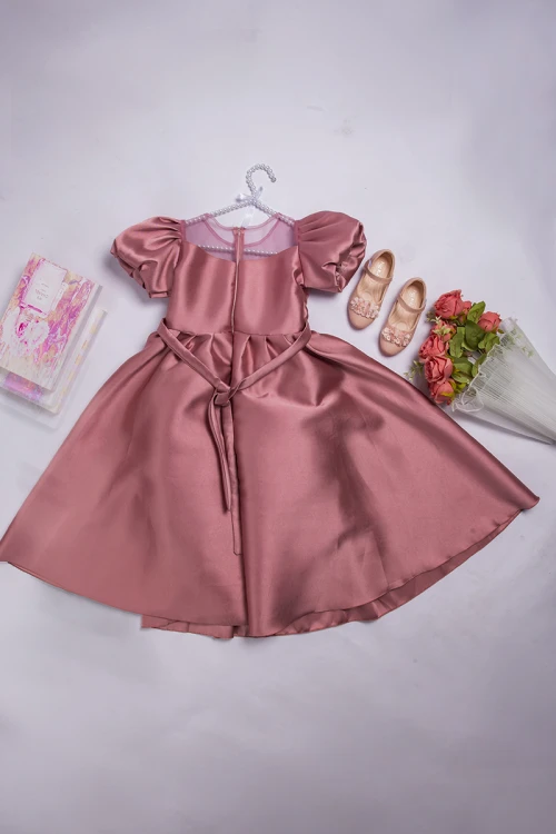 فستان بناتي أنيق لون وردي أكمام منفوشة وصدر قماش تل شفاف بتطريز كريستال فضي وفيونكة كبيرة على الخصر