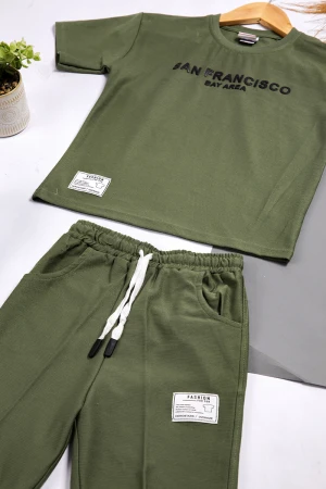 طقم ولادي أنيق قطعتين أكمام قصيرة و كتابة باللون الاسود وشعار من الأمام مع شورت بجيوب و رباط على الخصر 