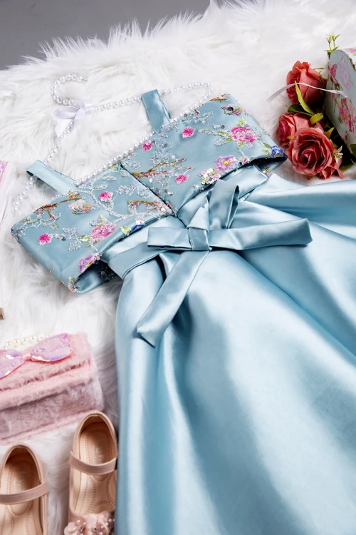 فستان بناتي أنيق لون تركواز سادة  بتطريز قماش مشجر على الصدر و الأكتاف وكسرات ورباط من الخصر