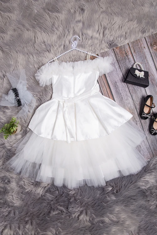 فستان بناتي أنيق لون أبيض علاقي من اللؤلؤ و كرانيش دانتيل بالصدر والأكتاف والأسفل مزين بحزام كريستال ولؤلؤ من الأمام و رباط من الخلف