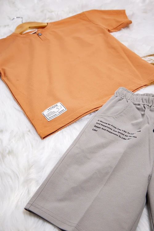 طقم ولادي قطعتين أنيق تيشرت لون برتقالي أكمام قصيرة و زر قفل من الأمام و شورت باللون الرمادي ورباط على الخصر