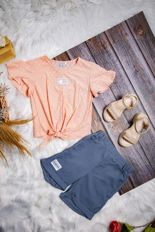 طقم بناتي أنيق قطعتين بلوزة لون برتقالي فاتح بشعار و رباط من الأمام و شورت مطاطي باللون الرمادي