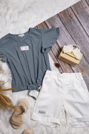 طقم بناتي أنيق قطعتين بلوزة لون برتقالي فاتح بشعار و رباط من الأمام و شورت مطاطي باللون الرمادي 