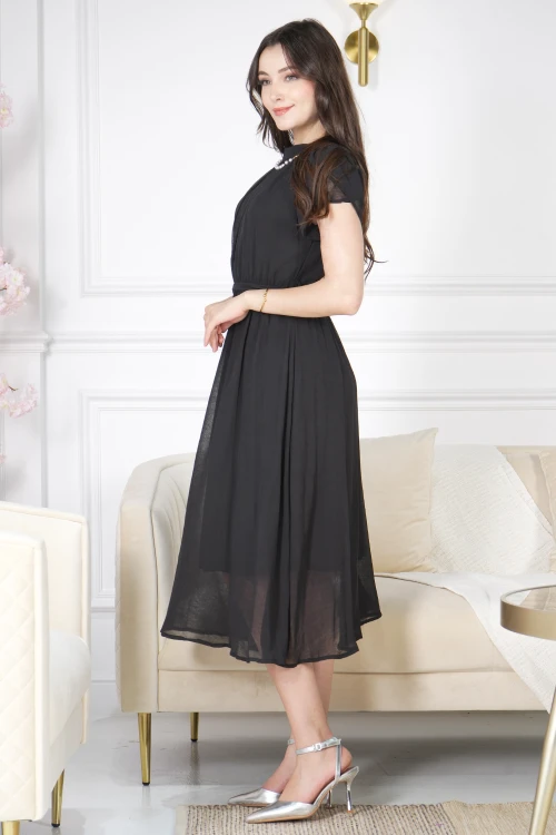 فستان نسائي أنيق لون أسود قصير و أكمام قصيرة قماش شيفون ياقة عالية بسلسال وكسرات بزم من الامام ورباط على الخصر