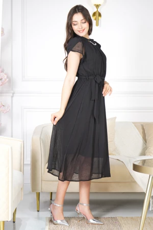 فستان نسائي أنيق لون أسود قصير و أكمام قصيرة قماش شيفون ياقة عالية بسلسال وكسرات بزم من الامام ورباط على الخصر  