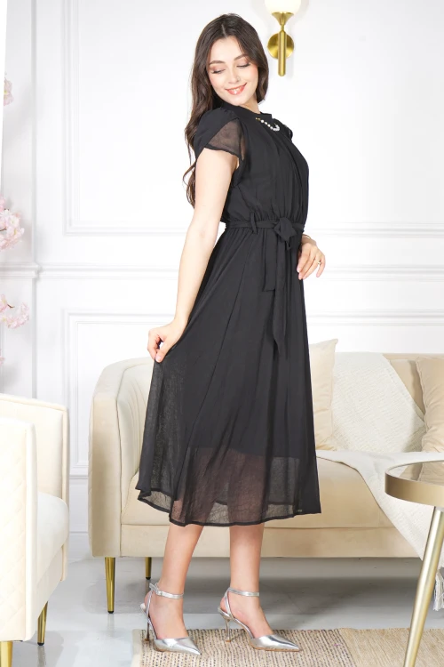 فستان نسائي أنيق لون أسود قصير و أكمام قصيرة قماش شيفون ياقة عالية بسلسال وكسرات بزم من الامام ورباط على الخصر