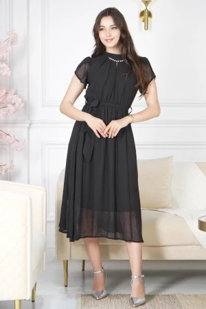 فستان نسائي أنيق لون أسود قصير و أكمام قصيرة قماش شيفون ياقة عالية بسلسال وكسرات بزم من الامام ورباط على الخصر  