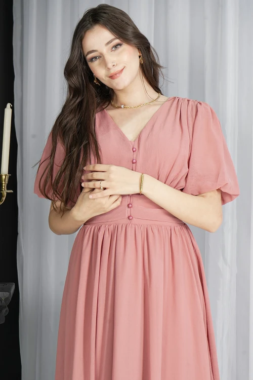 فستان نسائي انيق لون وردي سادة بأكمام قصيرة و فتحة صدر شكل سبعة و أزرار من الأمام