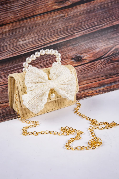 شنطة بناتي أنيقة لون ببيج مع فيونكة باللون السكري  مع مسكة مزينة باللؤلؤ وسلسال ذهبي