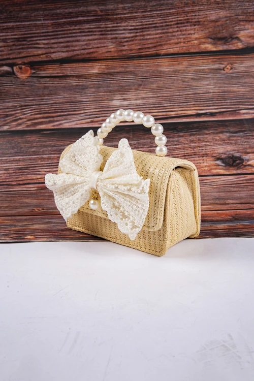 شنطة بناتي أنيقة لون ببيج مع فيونكة باللون السكري  مع مسكة مزينة باللؤلؤ وسلسال ذهبي