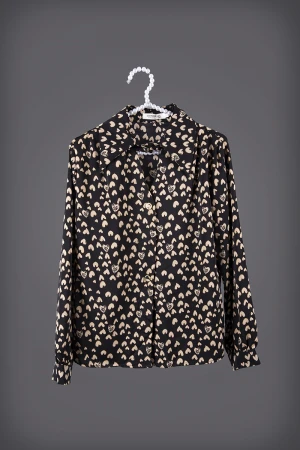 بلوزه نسائي أنيقة لون أسود بطبعات قلوب لون بيج أكمام طويلة و ياقة بقفل وأزرار من الأمام  