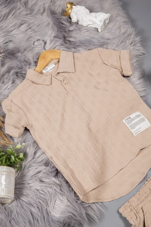 طقم ولادي قطعتين لون بيج أكمام قصيرة بياقة وأزرار قفل وطبعات من الامام وشورت بجيوب و رباط من الخصر