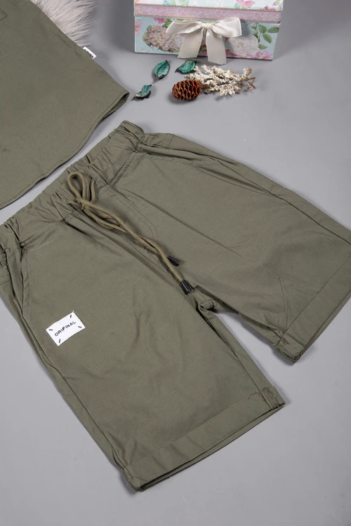 طقم ولادي قطعتين لون زيتي أكمام قصيرة بياقة عالية بأزرار قفل وجيب بطبعات من الامام وشورت بجيوب و رباط من الخصر