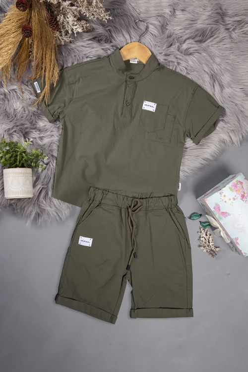 طقم ولادي قطعتين لون زيتي أكمام قصيرة بياقة عالية بأزرار قفل وجيب بطبعات من الامام وشورت بجيوب و رباط من الخصر
