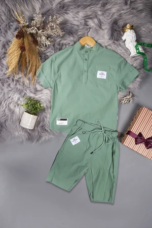 طقم ولادي قطعتين لون أخضر أكمام قصيرة بياقة عالية بأزرار قفل وجيب بطبعات من الامام وشورت بجيوب و رباط من الخصر