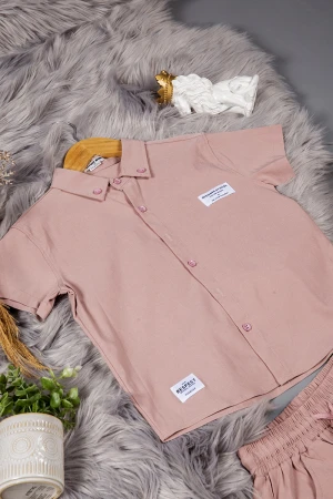 طقم ولادي قطعتين لون وردي أكمام قصيرة بياقة بأزرار قفل وجيب بطبعات من الامام وشورت بجيوب و رباط من الخصر