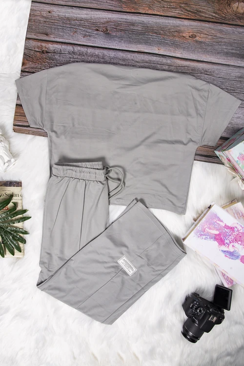 طقم نسائي أنيق قطعتين تي شيرت أكمام قصيرة بكتابات وجيوب من الأمام و بنطلون برباط على الخصر