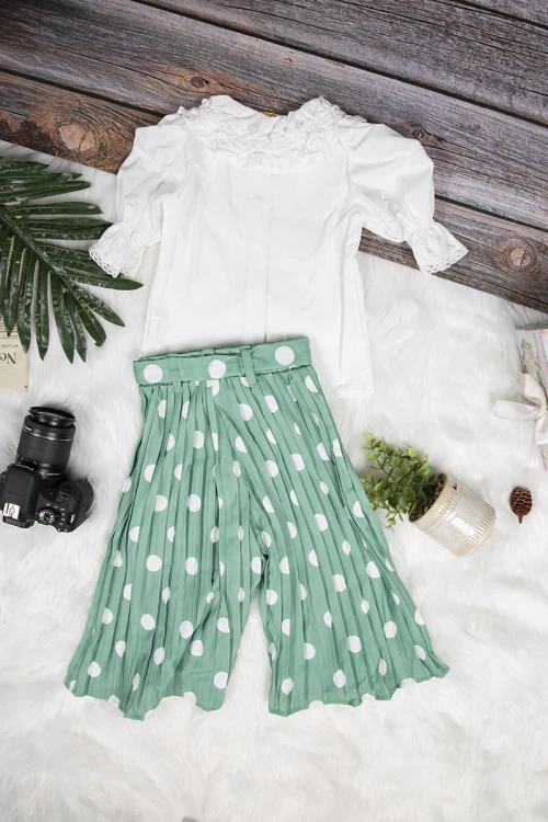 طقم بناتي أنيق قطعتين قميص لون أبيض بأزرار أمامية وبنطلون واسع بكسرات باللون الأخضر منقط باللون الأبيض و رباط على الخصر