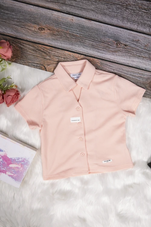 طقم بناتي أنيق قطعتين قميص كم قصير باللون الوردي الفاتح بأزرار من الأمام وبنطلون باللون الأسود واسع بجيوب من الأمام ورباط على الخصر