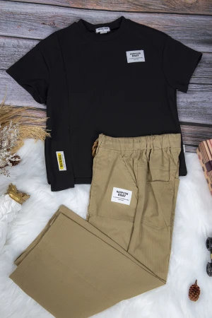 طقم ولادي قطعتين أنيق تي شيرت لون أسود بلوقو من الأمام وبنطلون بيج واسع طويل برباط على الخصر
