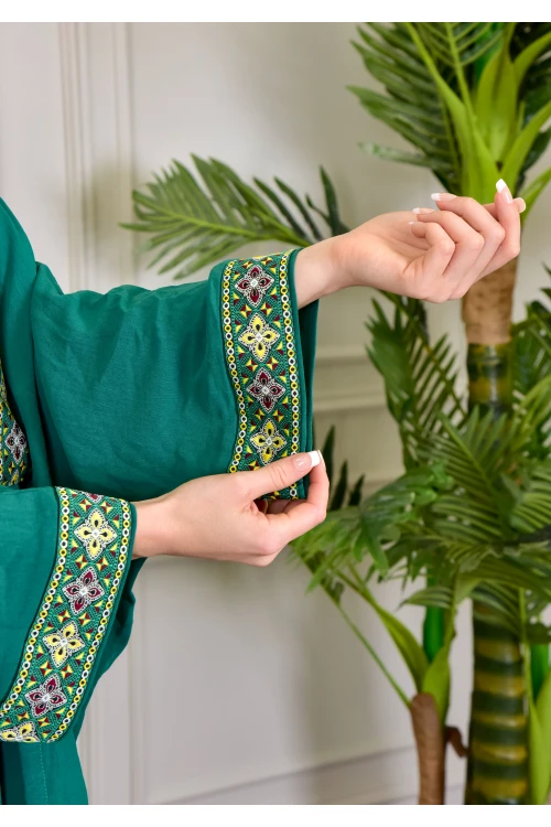 جلابية نسائي أنيقة قطعتين لون أخضر بأطراف مطرزة باللون الذهبي على الصدر و الأكمام الطويلة و برباط من الأمام