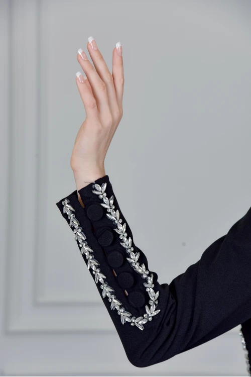 فستان نسائي سهرة أنيق طويل لون أسود أكمام طويلة بفتحة مثلثة من الصدر وفتحة صغيرة من الأسفل  ومزين بكريستال فضي من الخصر و الأكمام