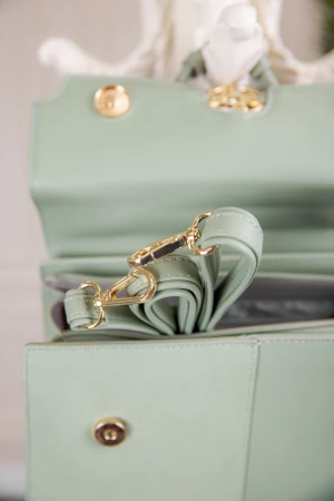 حقيبة يد نسائية لون أخضر مزينة بميدالية مع حمالة للكتف