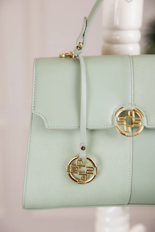 حقيبة يد نسائية لون أخضر مزينة بميدالية مع حمالة للكتف