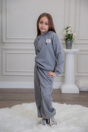 طقم بناتي أنيق قطعتين لون رمادي مع قبعة هودي و أكمام طويلة مع كتابة أمامية و بنطلون بجيوب و مطاط من الأسفل