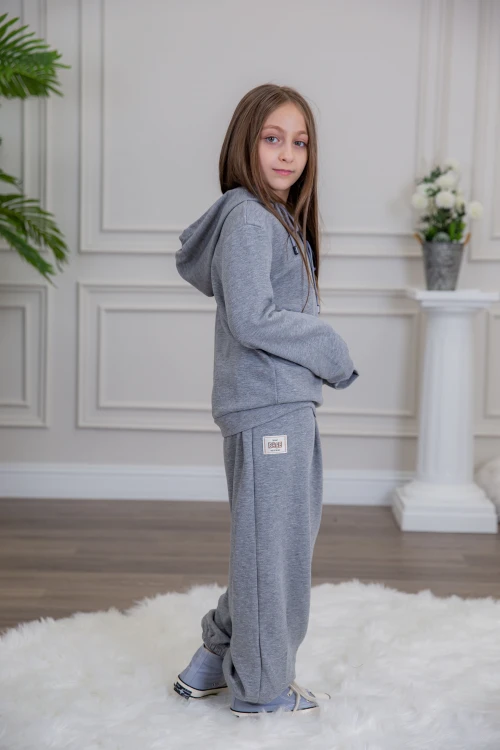 طقم بناتي أنيق قطعتين لون رمادي مع قبعة هودي و أكمام طويلة مع كتابة أمامية و بنطلون بجيوب و مطاط من الأسفل
