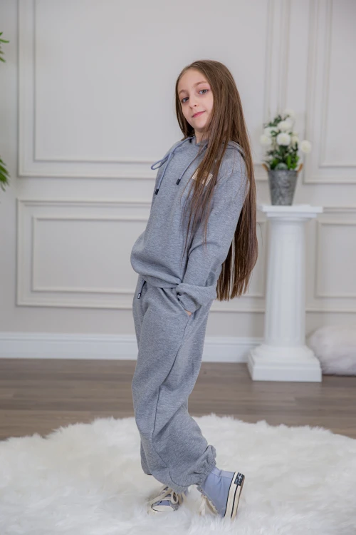 طقم بناتي أنيق قطعتين لون رمادي مع قبعة هودي و أكمام طويلة مع كتابة أمامية و بنطلون بجيوب و مطاط من الأسفل