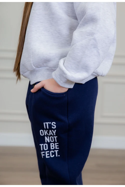 طقم بناتي أنيق قطعتين لون رمادي وكحلي مع قبعة هودي أكمام طويلة مزين بكتابات و بنطلون بجيوب و مطاط من الأسفل