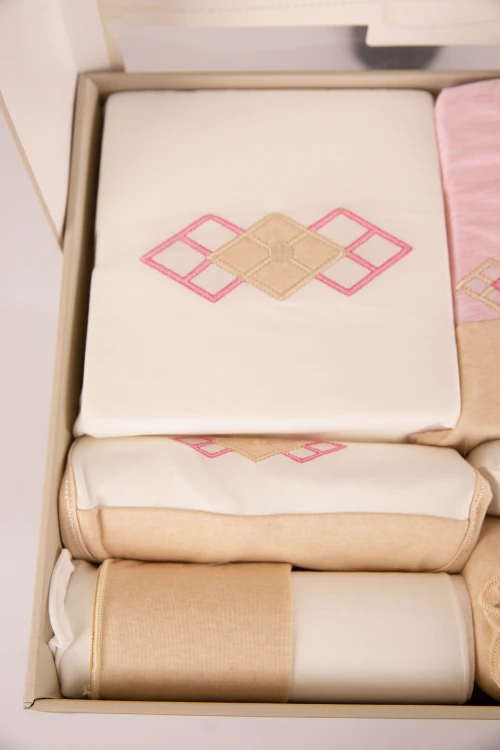 طقم هدايا مواليد 8 قطع لون وردي وبيج مزينة برسومات كرتونية