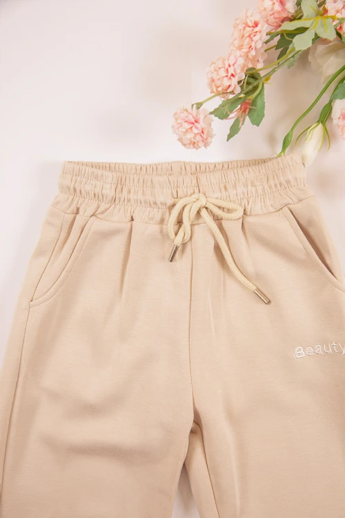 طقم بناتي شتوي قطعتين لون بيج بأكمام طويلة وقبعة متصلة مع بنطلون طويل بزم و رباط على الخصر