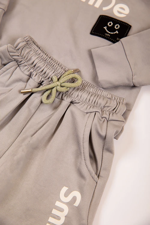 طقم بناتي شتوي قطعتين  لون بيج غامق بكتابات من الأمام و أكمام طويلة و رباط و زم من الخصر